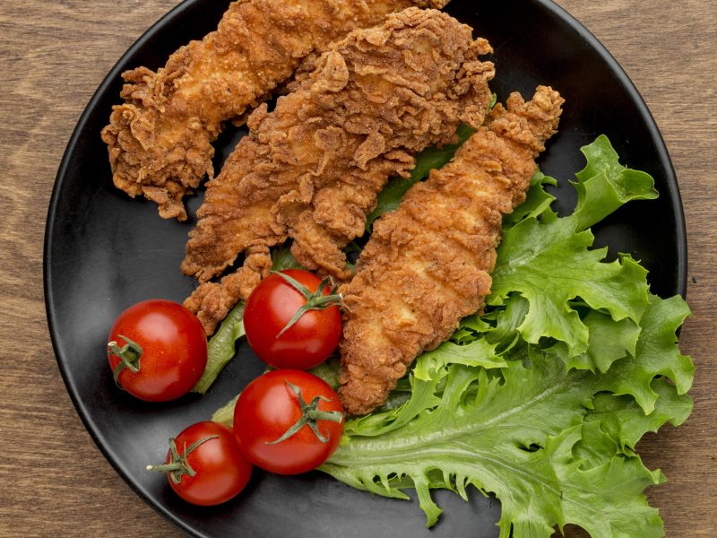 top-view-fried-chicken-with-tomatoes-salad-plate